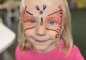 dziewczynka z twarzą pomalowaną za motylka